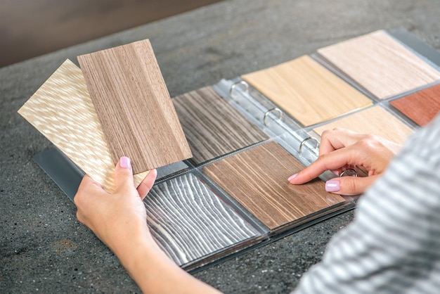 Photo samples of wood in hands closeup a woman designer selects wood samples from a collection for a project high quality photo