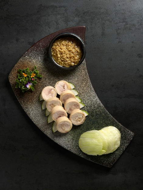 Samsui Ginger Chicken Roll with ginger past and cucumber served in a dish isolated on table top view