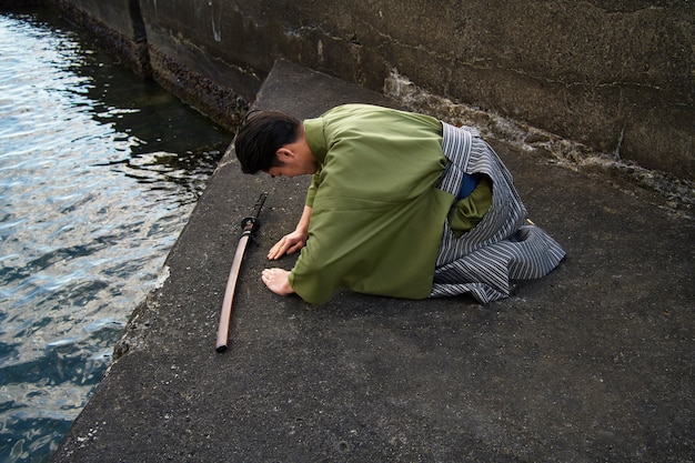 Foto samurai che fa un inchino sulla sua spada