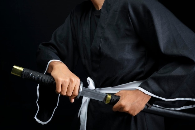 Воин-самурай сжимает меч на черном фоне