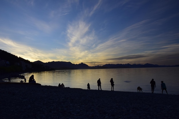 San Carlos de Bariloche Argentina 05 march 2017 Tourists rest on pebble beach of Nahuel Huapi Lake Night shot