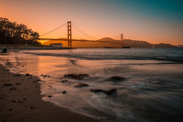 San francisco, californië, verenigde staten. lange blootstelling aan de rode zonsondergang bij de golden gate of san francisco vanaf het strand