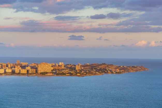 San Juan and Cabo las Huertas seen from Santa Barbara Castle. Mediterranean Sea is calm and there are some clouds on the sky.