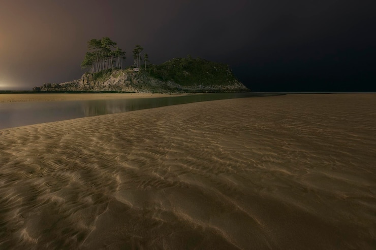 Photo san nikolas island in lekeitio on a cloudy night with a closeup of the beach sand textures