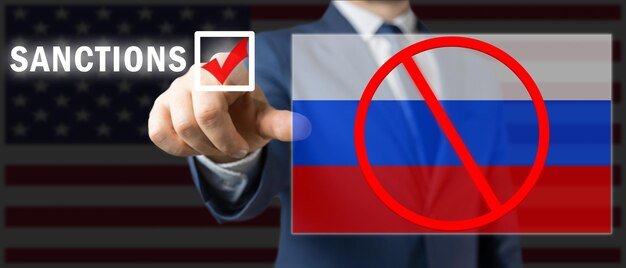 Sanctions against Russia concept politician man touches and chooses sanctions russian flag with red blocked sign