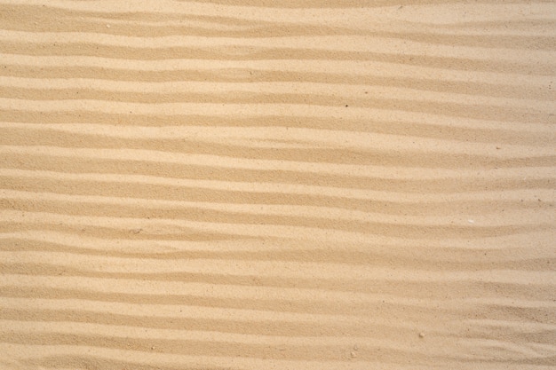 Предпосылка пляжа песка и картина текстуры с космосом.
