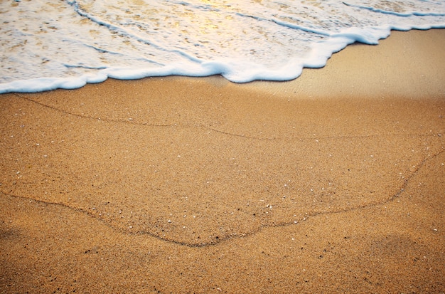 Sand on the beach by the sea at sunrise