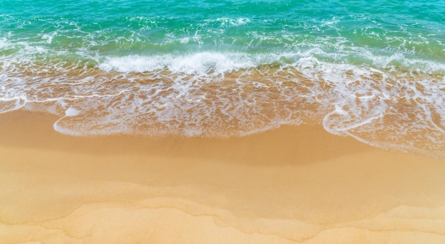 Photo sand beach seaside with white foamy and wave from blue sea landscape seashore in summer season