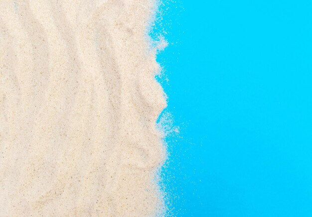 Sand on blue background Copy space for text Top view