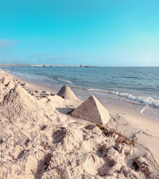 Sand castles in shape of pyramids on a beach on Baltic Sea