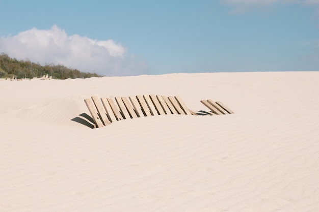 Фото Песчаная дюна, покрывающая забор на пляже