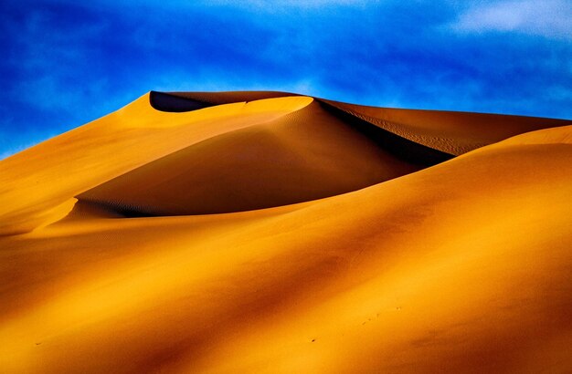 Sand dune in desert against sky