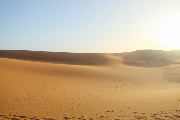 Фото Песчанные дюны против ясной предпосылки голубого неба в пустыне сахары.