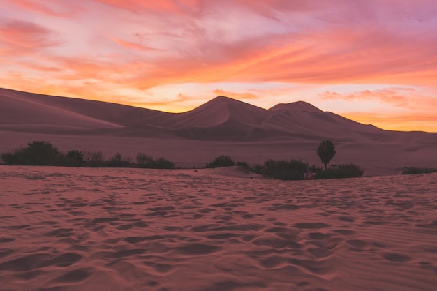sand dunes in desert against cloudy sky