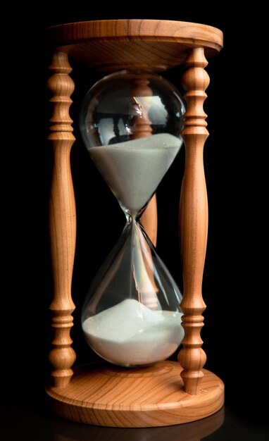 Photo sand flowing inside of hourglass