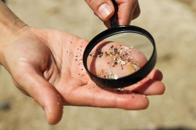 Photo sand on the hands under a magnifying glass