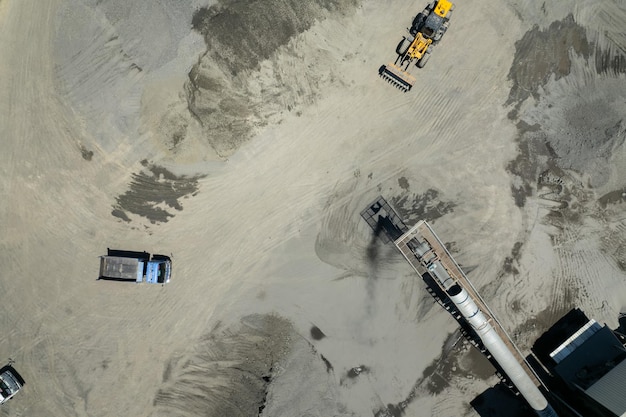 Sand loaders are shoveling rocks into dump trucks