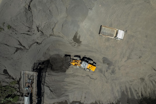 Sand loaders are shoveling rocks into dump trucks