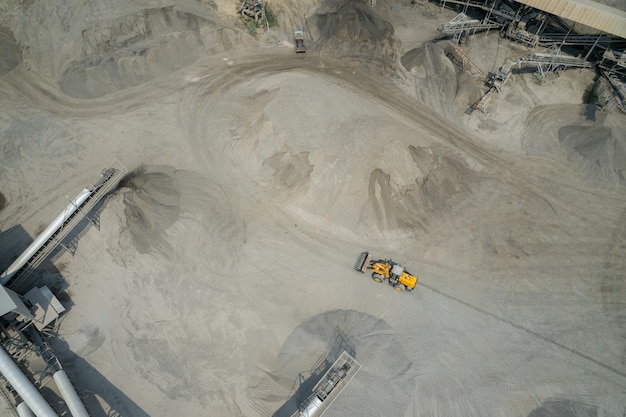 Sand loaders are shoveling rocks into dump trucks