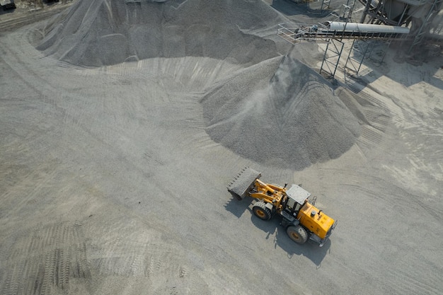 Sand loaders are shoveling rocks into dump trucks