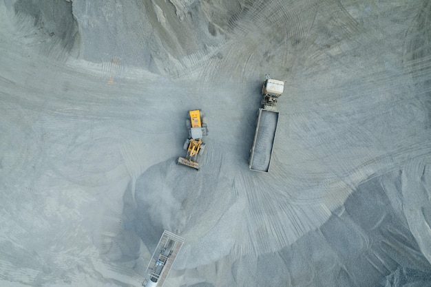 Sand loaders are shoveling rocks into dump trucks