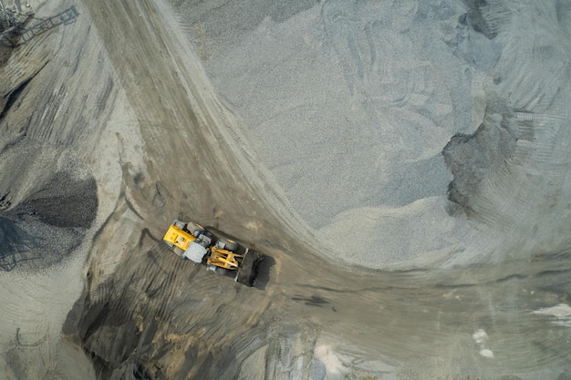 Sand loaders are shoveling rocks into dump trucks