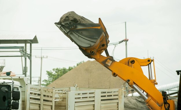 Photo sand loaders are shoveling rocks into dump trucks