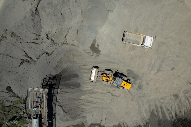 Sand loaders are shoveling rocks into dump trucks