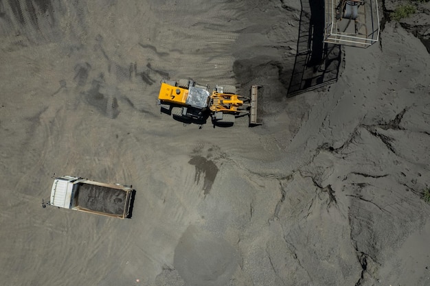 Sand loaders are shoveling rocks into dump trucks