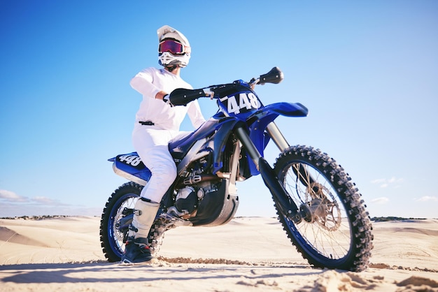 Sand motor sports and man drive with motorbike for adrenaline adventure and freedom in desert Action extreme sport and male person on bike on dunes for training exercise and race or challenge