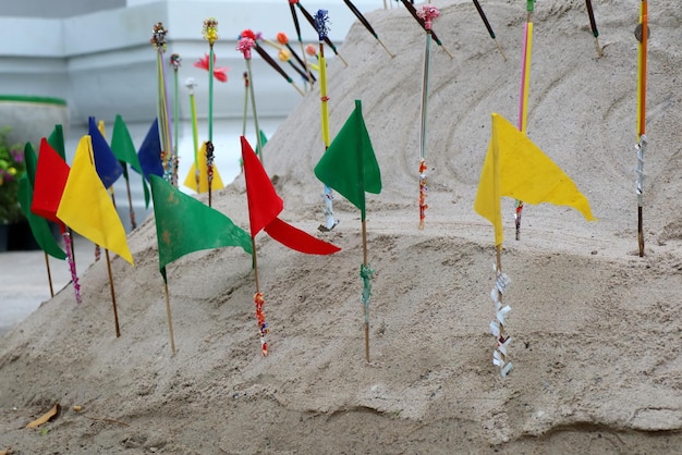Sand pagoda of Songkran festival Thailand with colorful paper flags on the pile of sand Culture