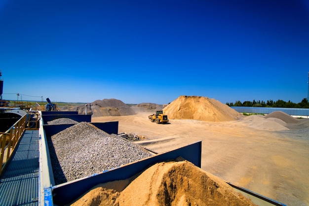 背景に砂と砂利の山がある砂採石場掘削装置ブルドーザー選択的焦点
