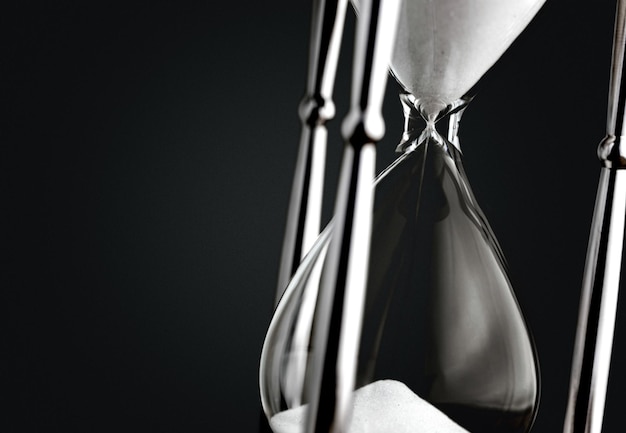 Sand running in hourglass on black background