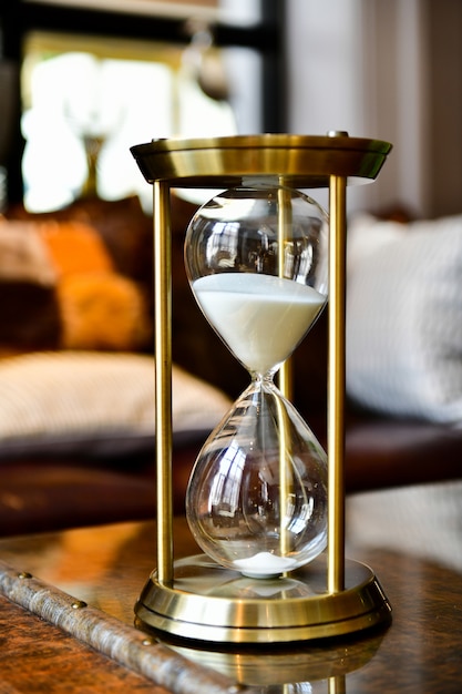 Sand running through the bulbs of an hourglass measuring the passing time in living room.Home decoration accessories