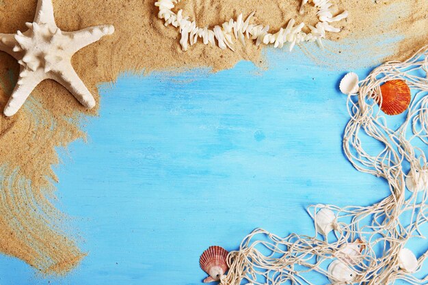 Sand and seashells with sand on wooden background