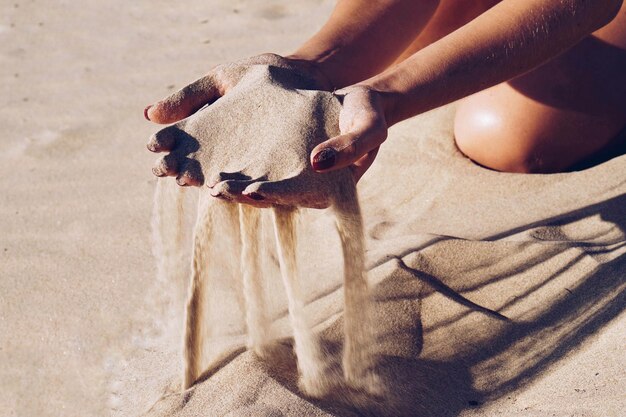 Sand spilling from cupped hands