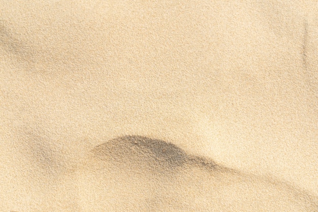 Foto fondo di struttura della sabbia. modello del deserto marrone dalla spiaggia tropicale. avvicinamento.