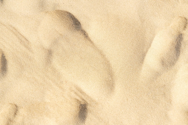 Photo sand texture on the beach. brown beach sand for background. close-up.