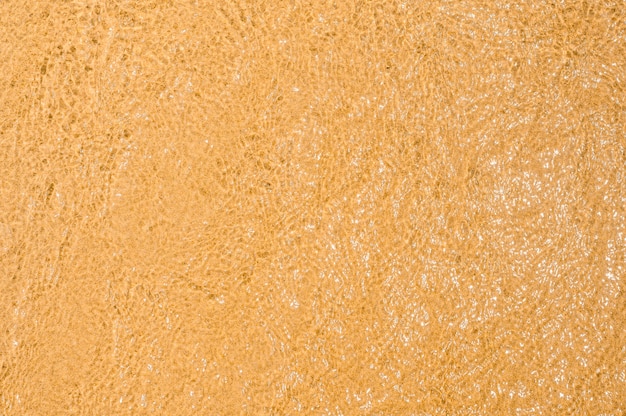 sand and water texture clear sea water waves on top golden sand on beach texture wet sand on beach