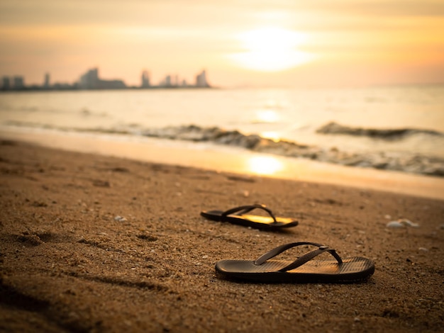 Sandalen Toerisme Vrouw op Zandstrand met Overlichte Zonsondergang Achtergrond aan KustFlip Flops met Water Shore Natuur in Schemering Gouden Lichtvoor Vakantiereizen in Tropische Zomervakanties of Gebroken Hart