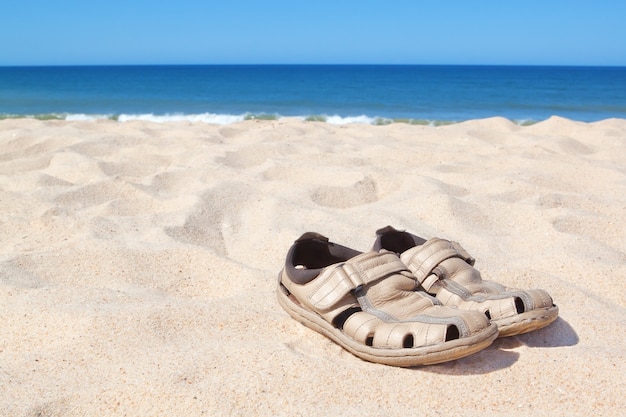 Sandals on the beach near the sea.