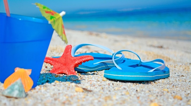 Sandals and drink on a tropical beach