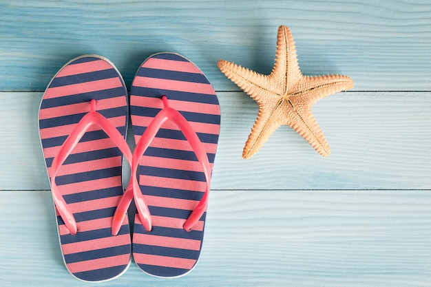 Sandals with starfish on a blue wooden floor,Summer concept