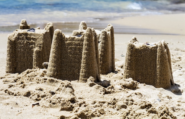 Sandcastles на пляже, концепция каникул, тонизированный.