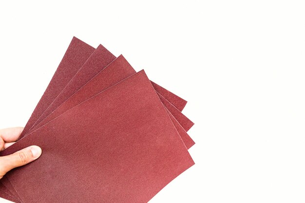 Sandpaper in hand isolated on white background.