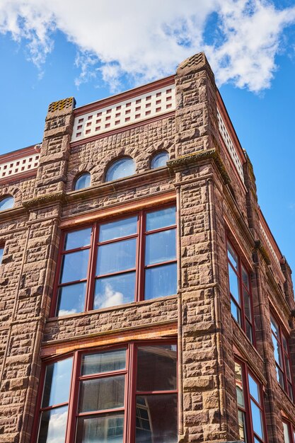 Sandstone Building Elegance with Arched Windows Sunny Sky Upward View