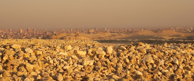 Песчаная буря над Каиром в Египте с размытыми камнями на переднем плане.