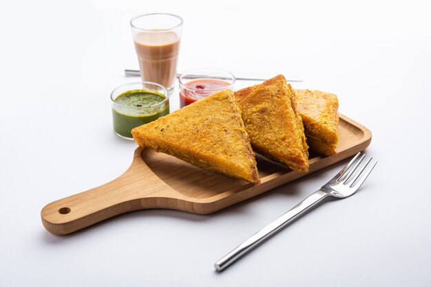 Sandwich Bread Pakora or triangle shape pakoda served with tomato ketchup, green chutney, Popular indian tea-time snack