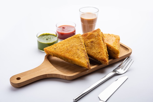 Sandwich Bread Pakora or triangle shape pakoda served with tomato ketchup, green chutney, Popular indian tea-time snack