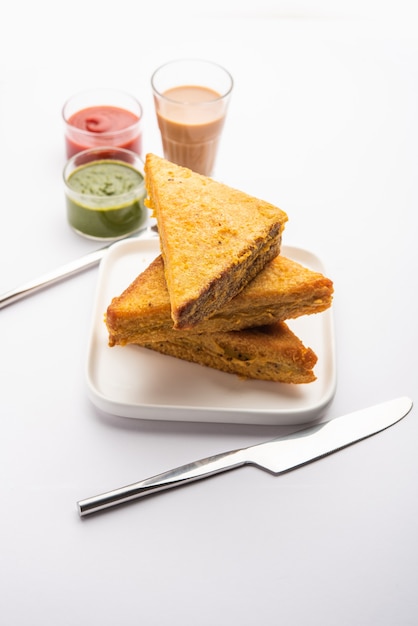 Хлеб-сэндвич Пакора или пакода треугольной формы подается с томатным кетчупом, зеленым чатни и популярной индийской закуской к чаепитию.